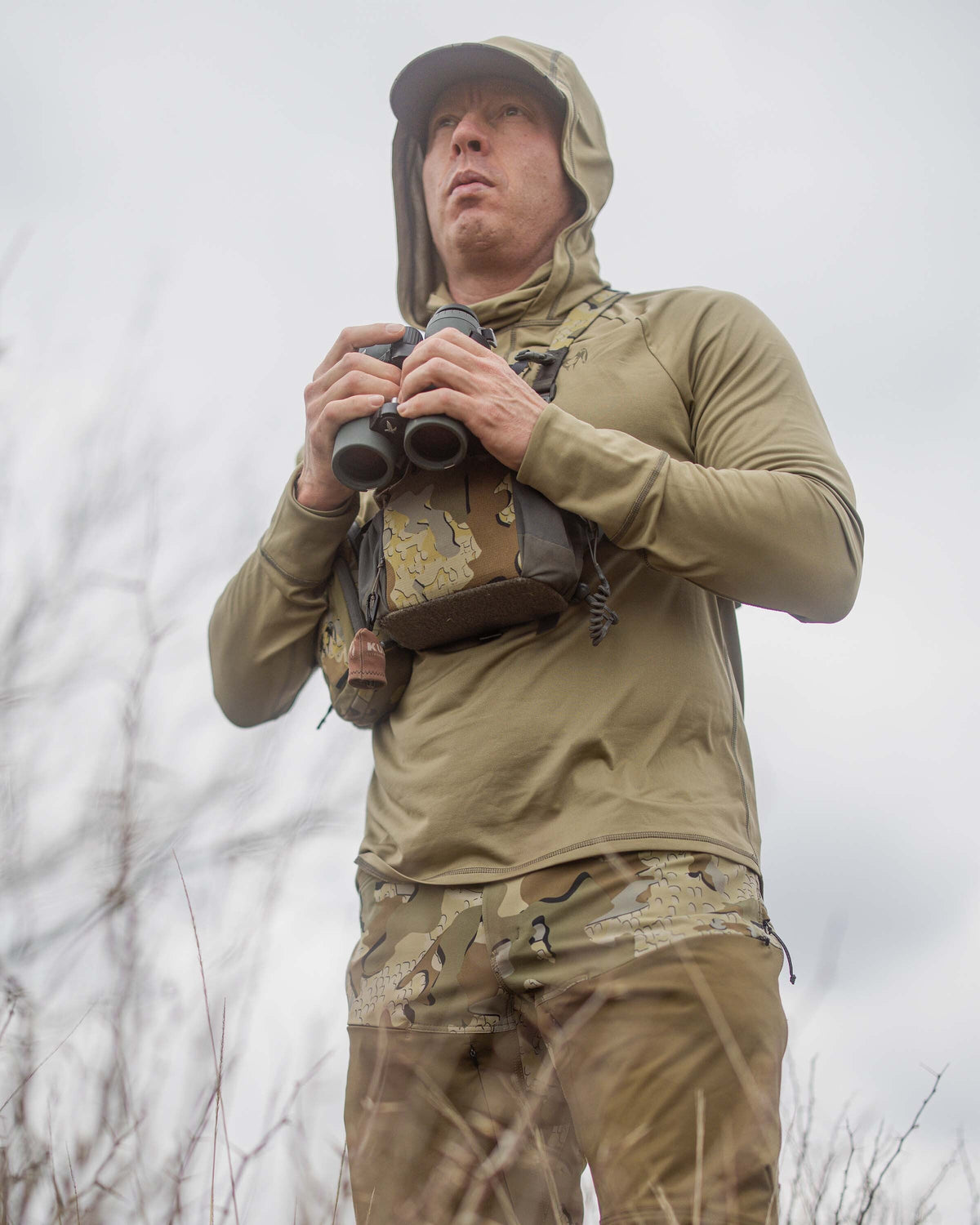 Hunting Holding Binoculars in Gila Pro Long Sleeve Hoodie in Khaki