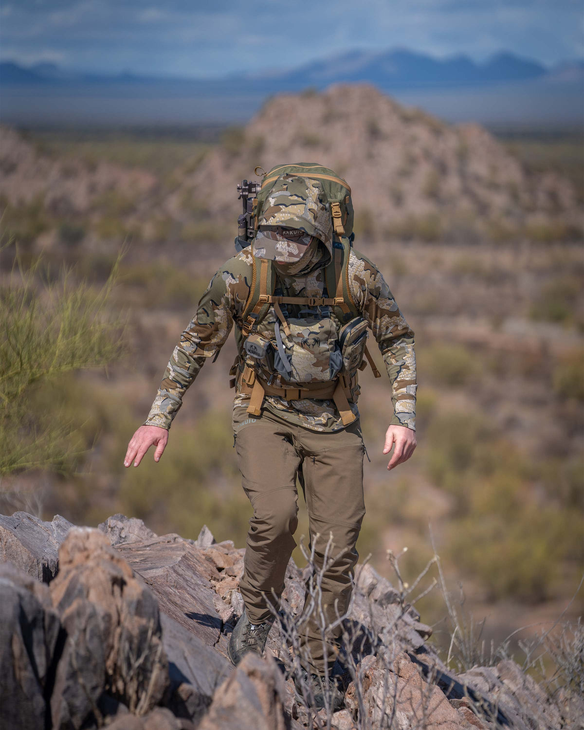 Hunter Hiking Up Rocky Hill in Mexico in Gila Pro Long Sleeve Hoodie in Valo Camouflage