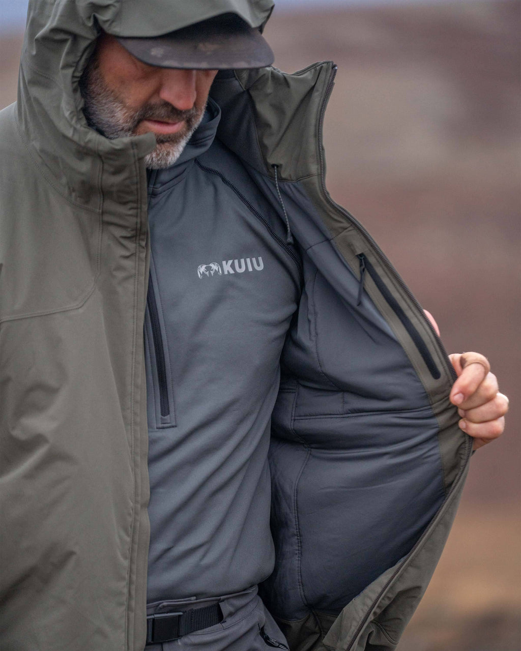 Hunter displaying internal active insulation material on Mountain PRO Hooded Jacket in Ash Brown