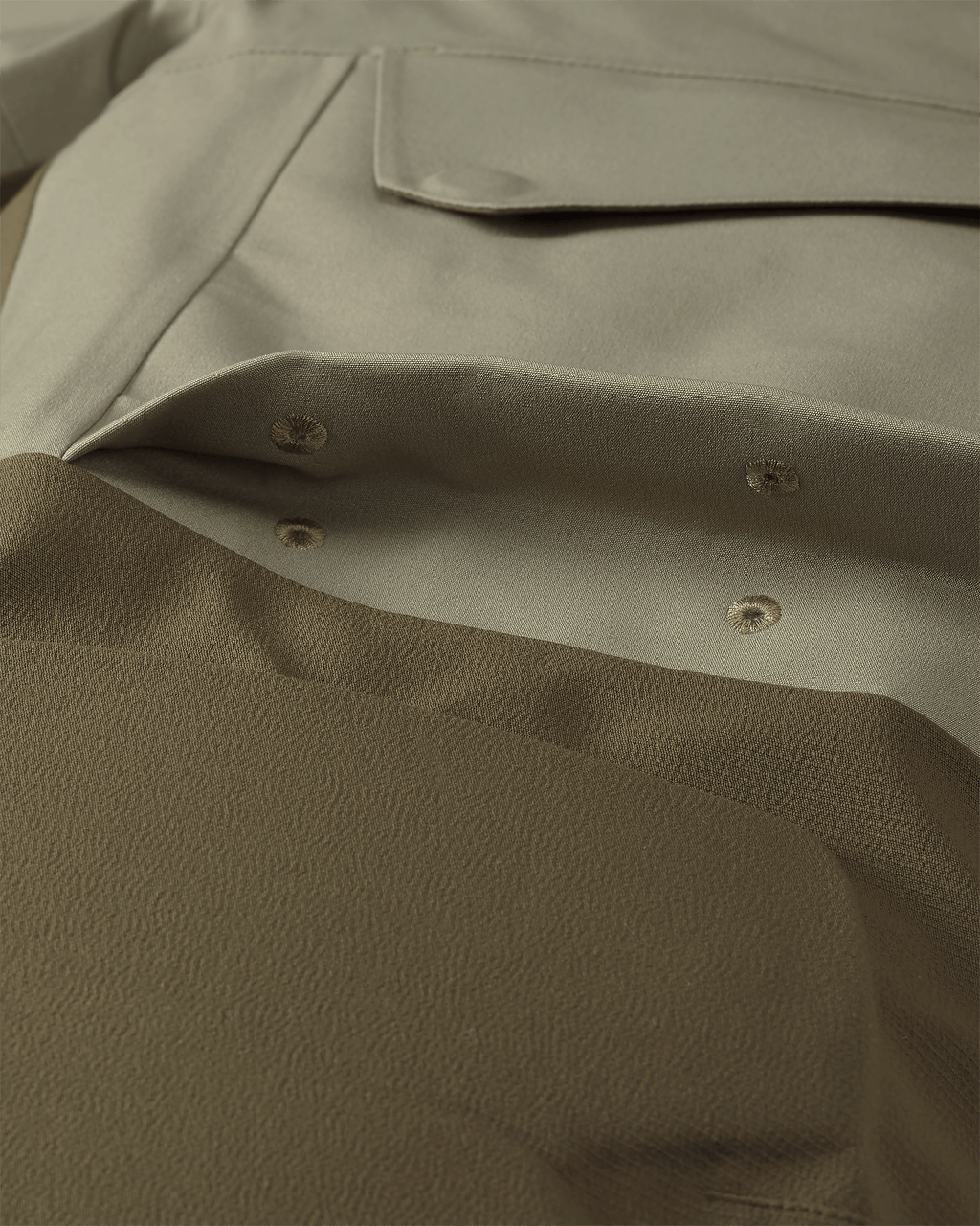 Detail of Billowed thigh pocket with drain holes and secure flap closure on KUIU Paragon Storm Shell Parka in Arctic Shadow Khaki