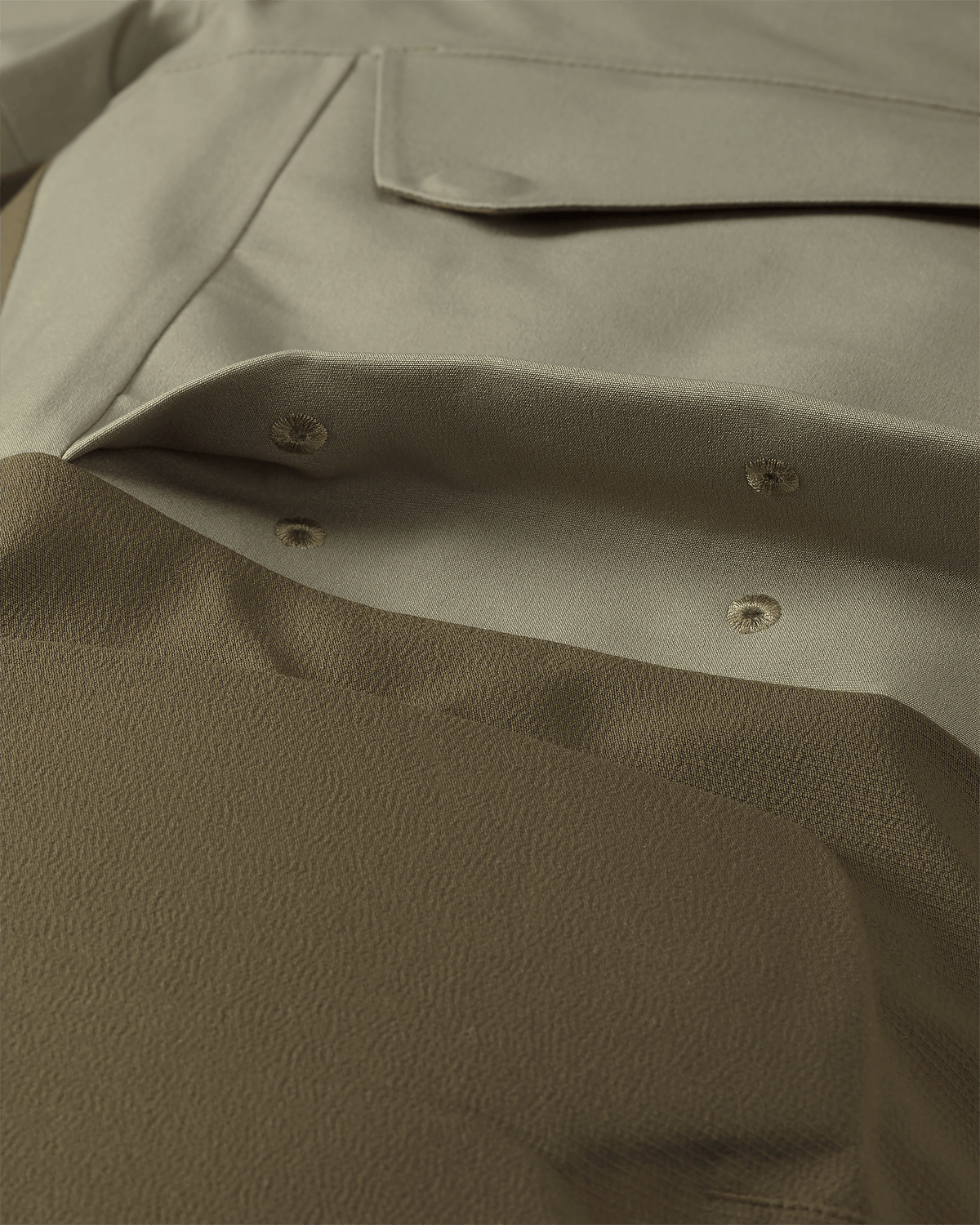 Detail of Billowed thigh pocket with drain holes and secure flap closure on KUIU Paragon Storm Shell Parka in Arctic Shadow Khaki