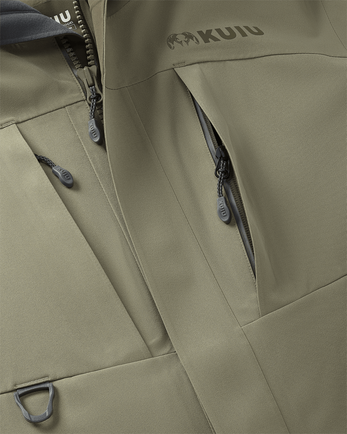 Close-up, front view of Paragon Storm Shell Parka in Arctic Shadow Khaki, Highlighting vertical zippered chest pockets and D-loop accessory attachment points at front chest
