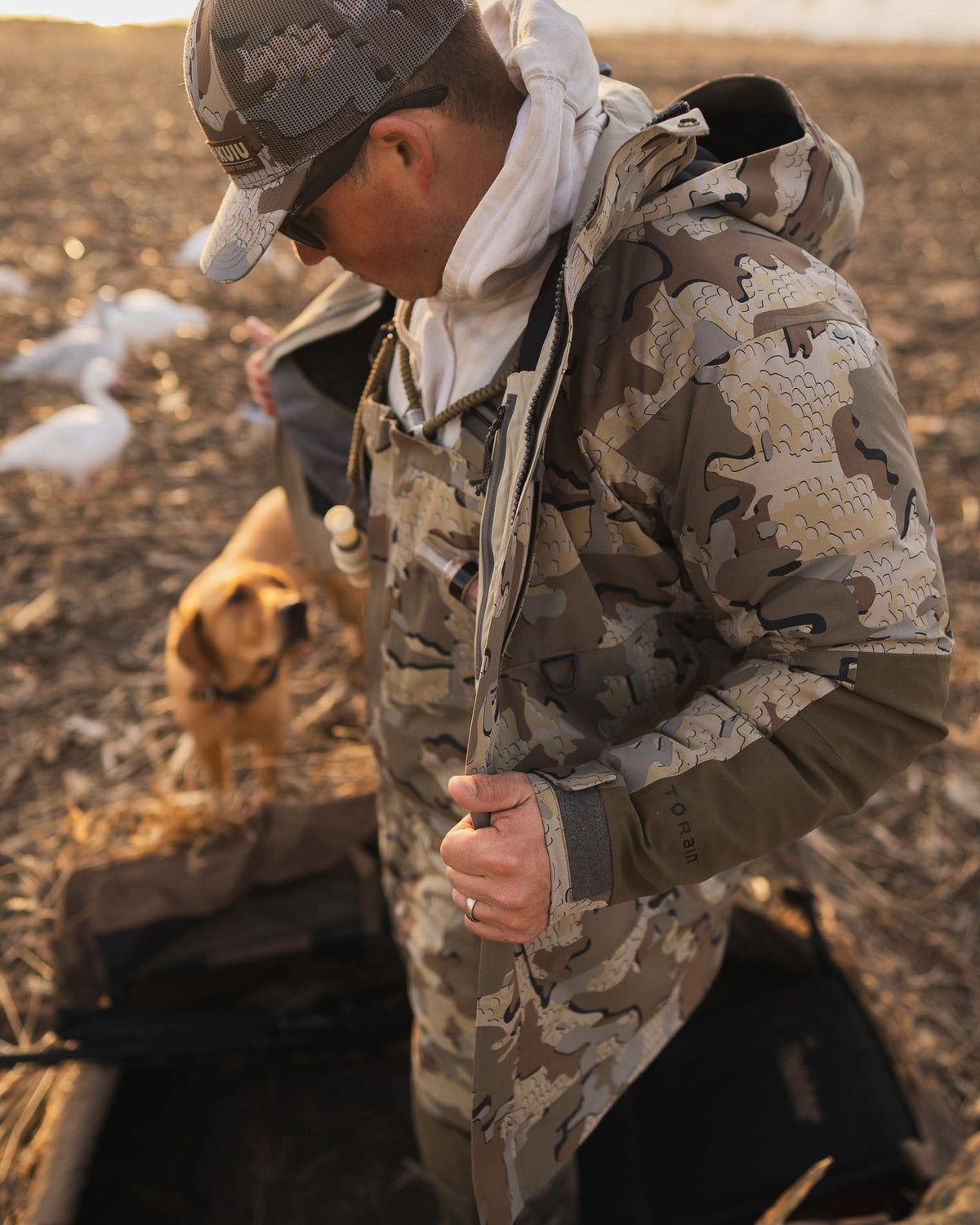 Waterfowl Hunter removing his Paragon Storm Shell Parka in Valo Camouflage