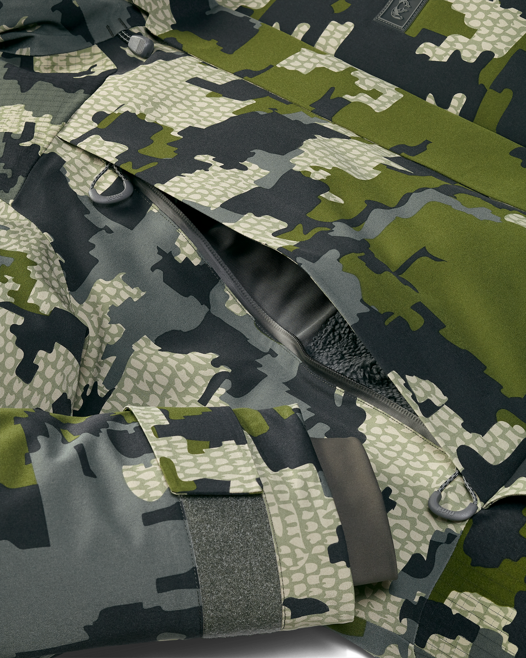 Detail of zippered chest pocket on Super Down Arktuk Parka in Verde Camouflage, Highlighting fleece lining hand pocket and adjustable velcro cuff closure