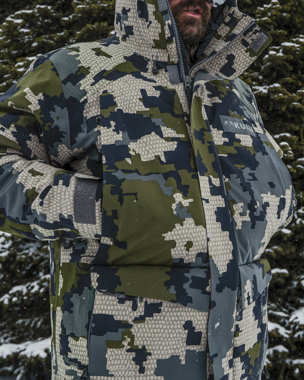 Close-up of hunter's hand warming in a sherpa fleece pocket on the Super Down Arktuk Parka in Verde Camouflage