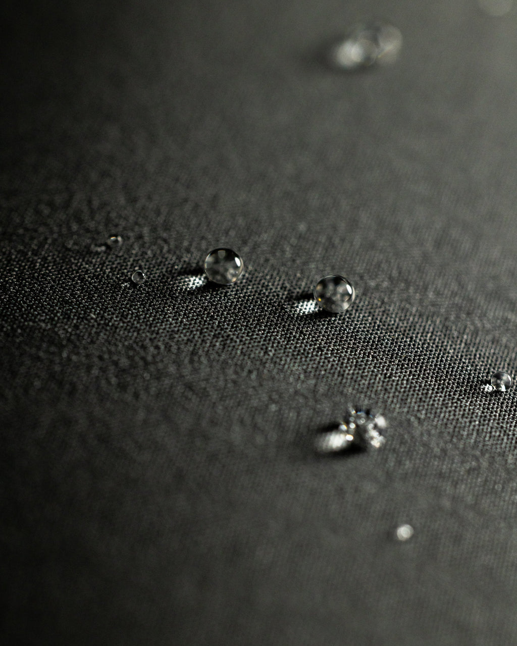 Macro view of water droplets resting on the fabric surface of Mountain PRO Hooded Jacket