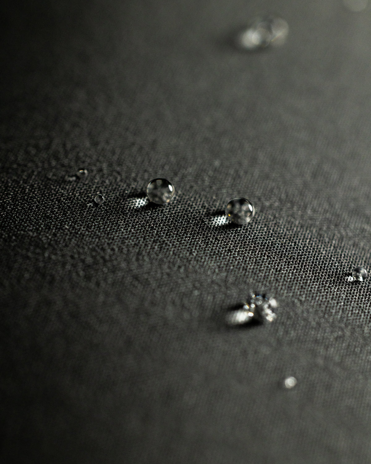 Macro view of water droplets resting on the fabric surface of Mountain PRO Hooded Jacket