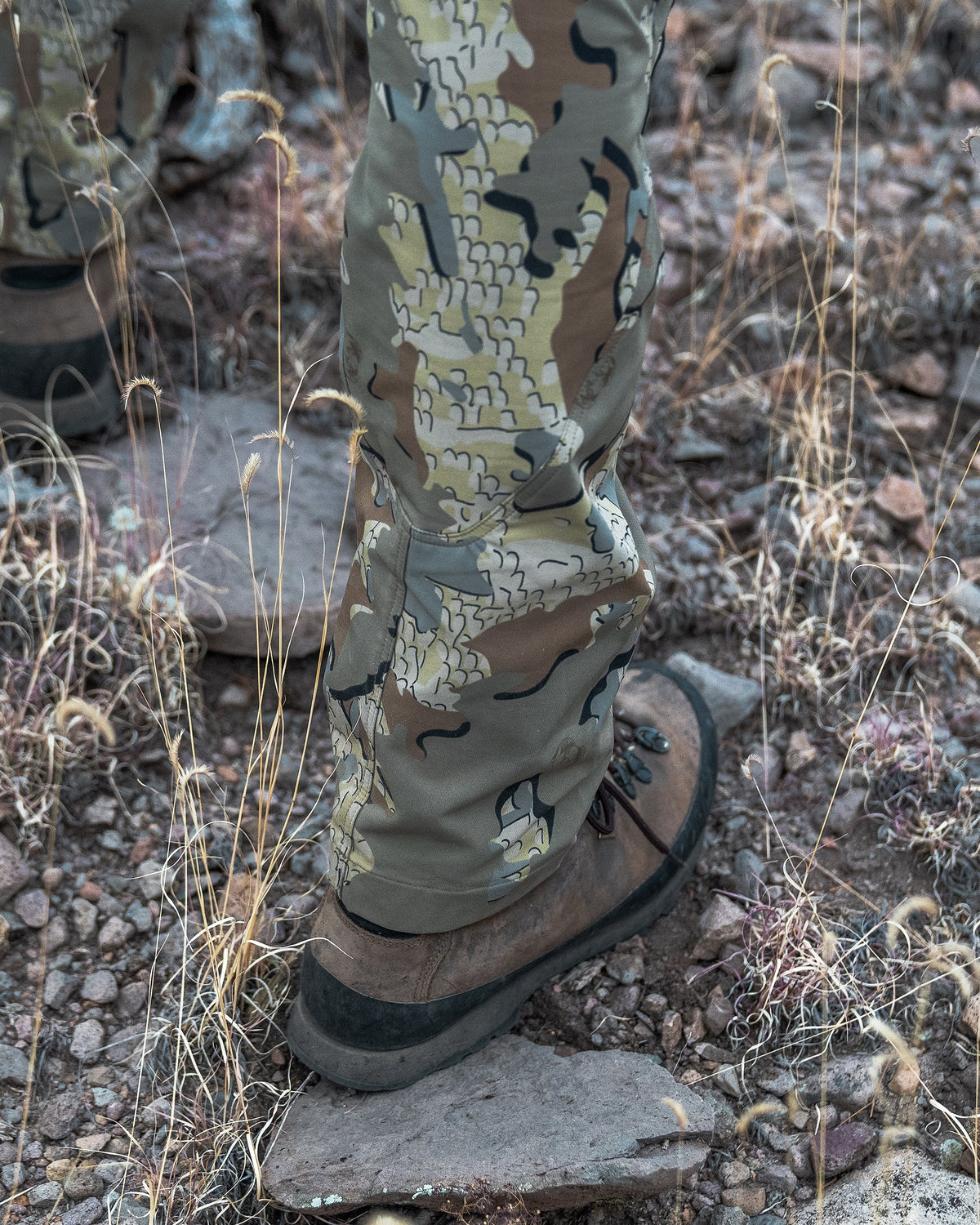 Field image of a hunter wearing a PRO Pant in Valo Camouflage showing the seam construction behind the heel and calf of the leg